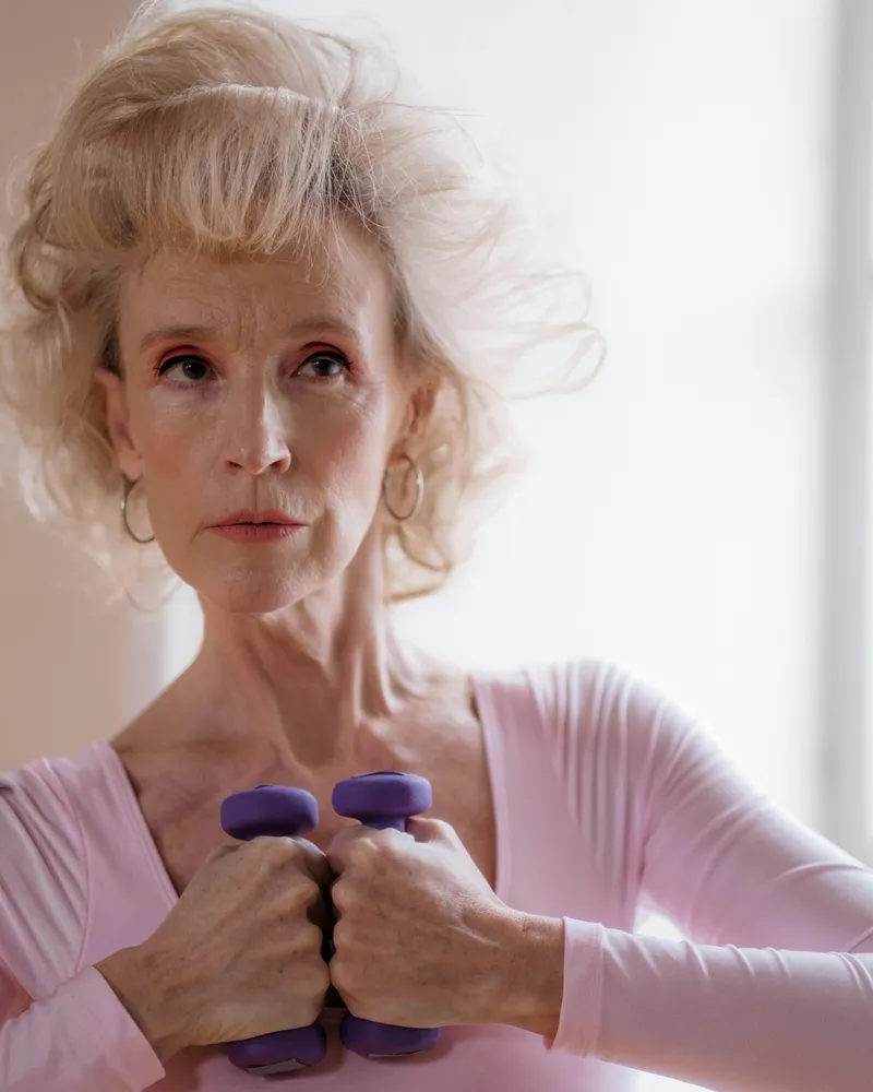 Active elderly woman holding dumbbells during a fitness and strength session