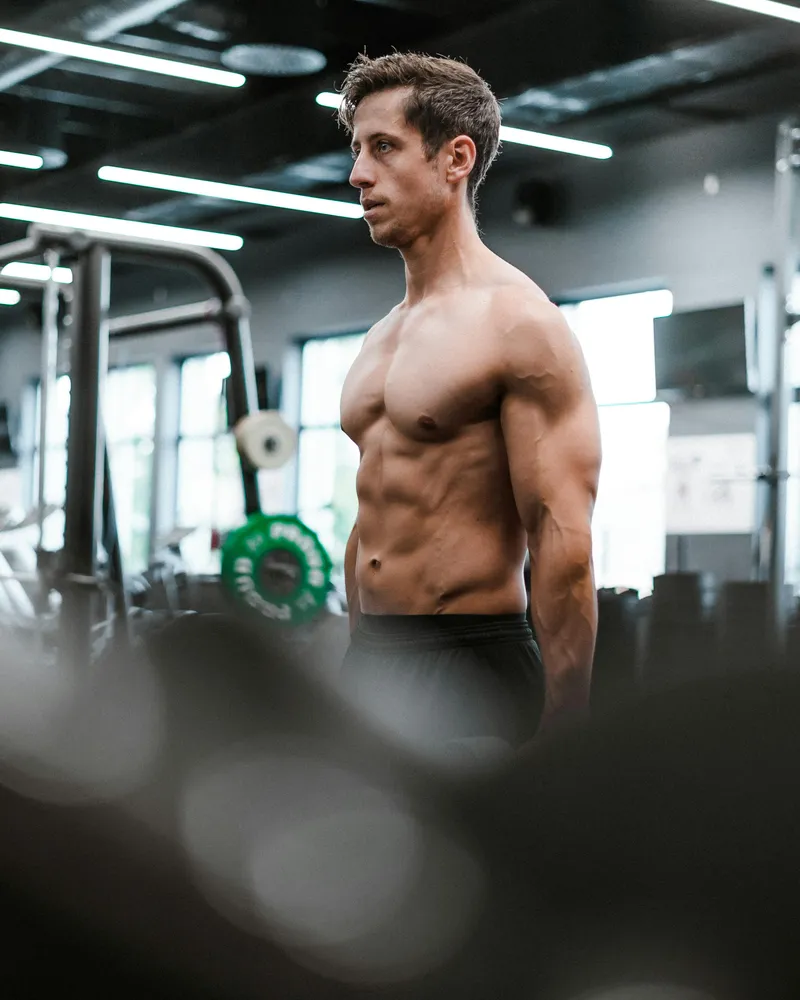 Muscular man showcasing strength and fitness results in the gym