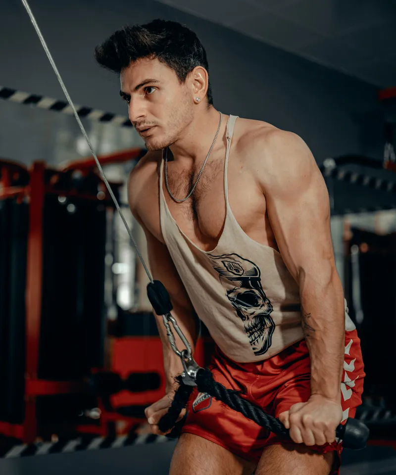 Athletic man performing cable machine tricep workout in a modern gym