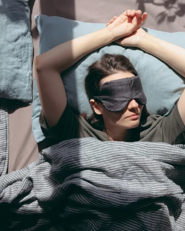 Woman stretching her arms in a cozy bedroom at home