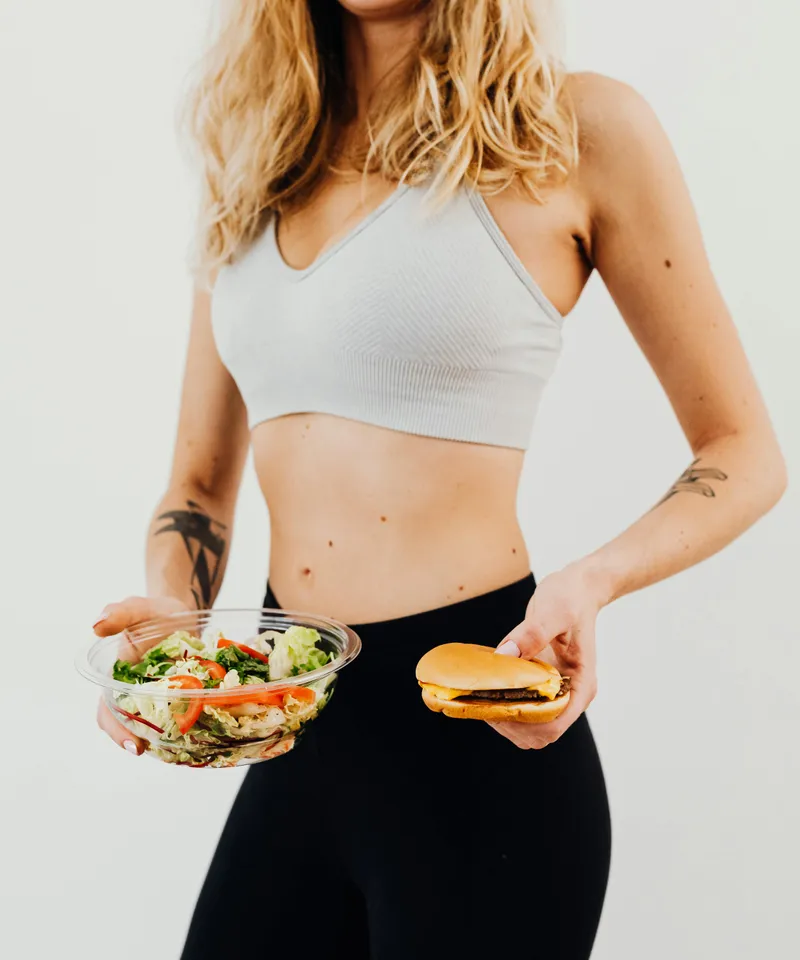 Woman in activewear holding fresh healthy food as part of a nutrition-focused lifestyle